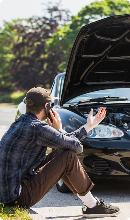 Driver receiving roadside assistance beside a vehicle